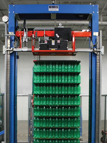 Rows of green plastic bottles being stacked on the bundling machine.