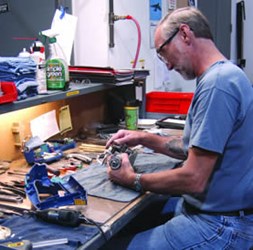 Man fixing OEM head parts on a working desk.