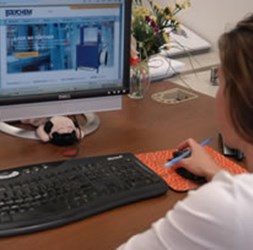 Woman sitting in front of the computer with the Polychem's site open.