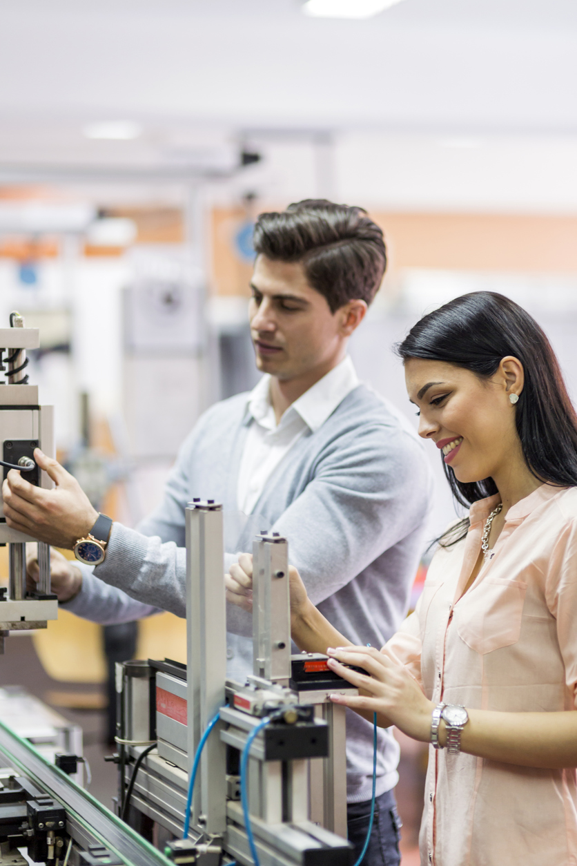 Man and a woman examining a machine.