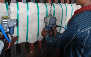 Two man bundling textile fiber with the hand tools.